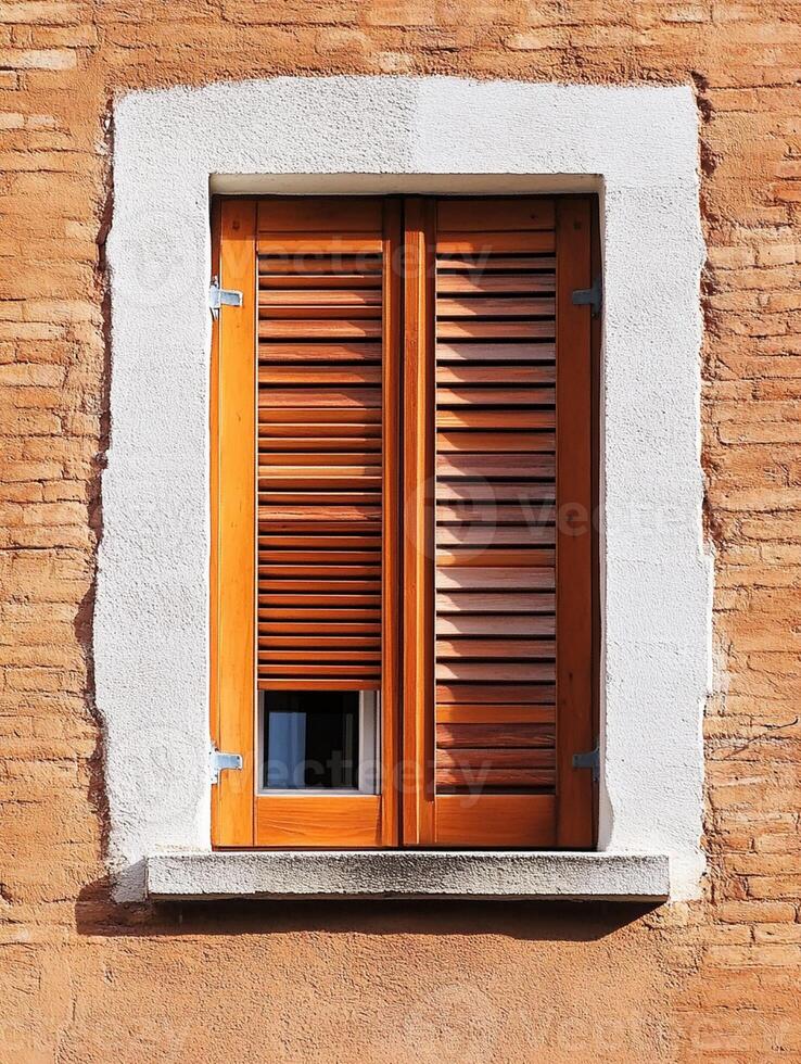 A window with shutters on a brick wall photo