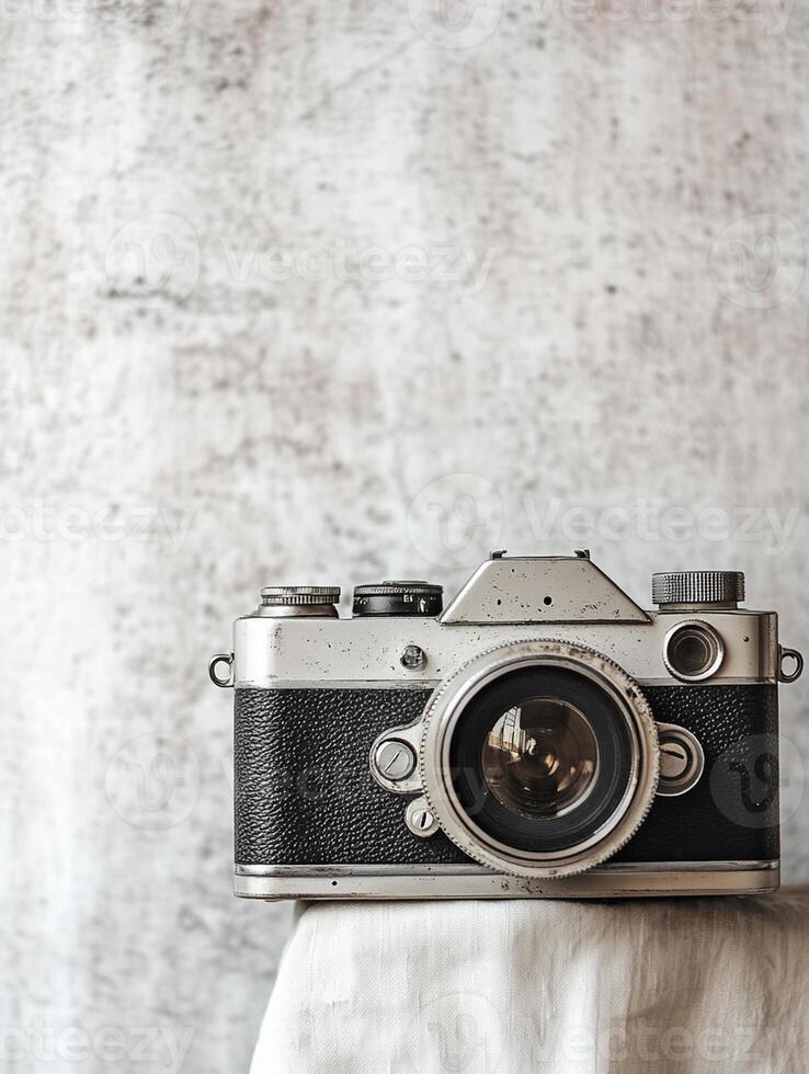 An old camera sitting on top of a white cloth photo