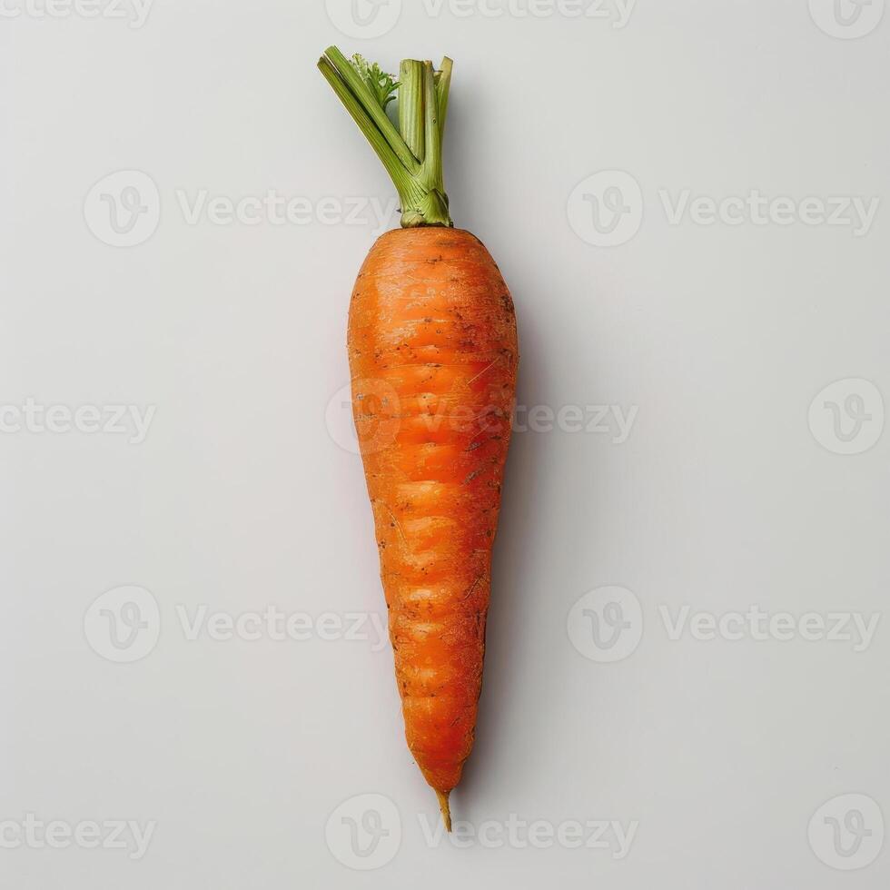 A whole, unpeeled carrot with green stem on a white background. photo