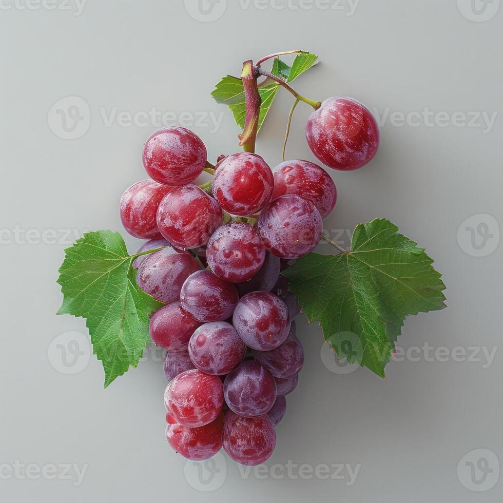 a bunch of grapes with green leaves on a white surface photo