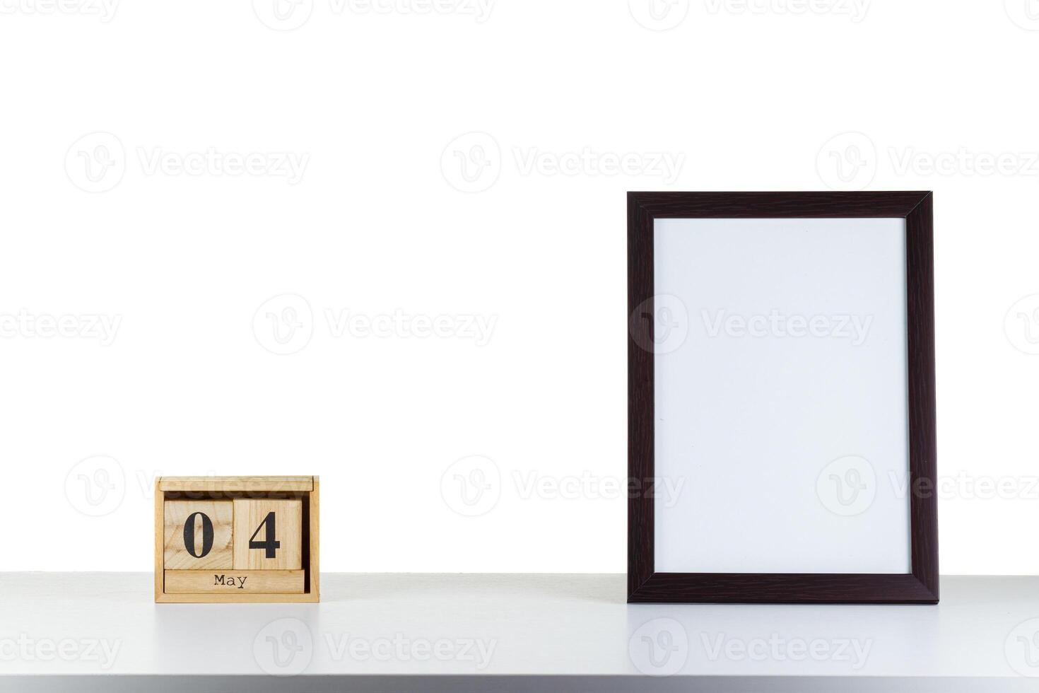 Wooden calendar 04 may with frame for photo on white table and background