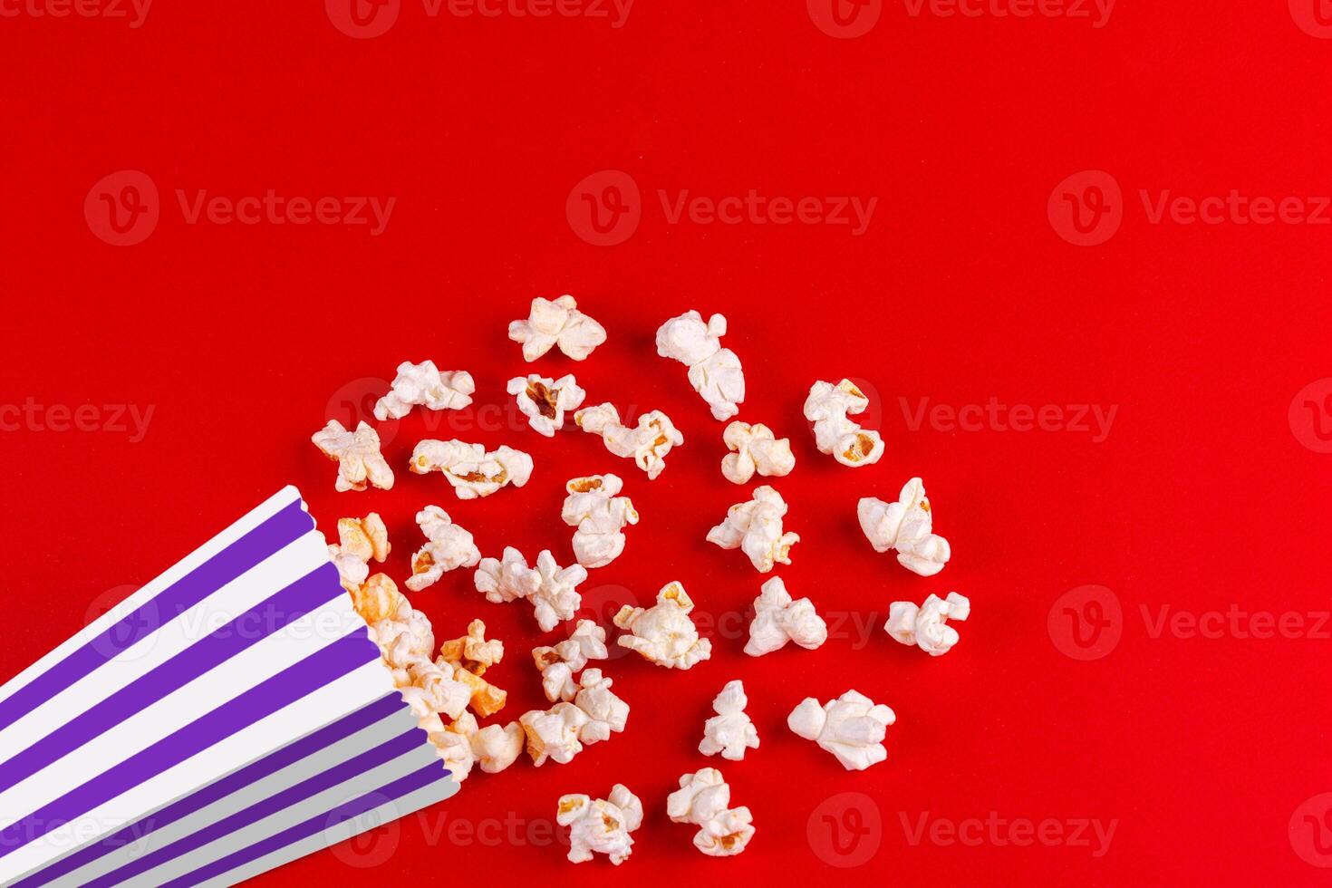 box with popcorn striped in different colors on a red background photo