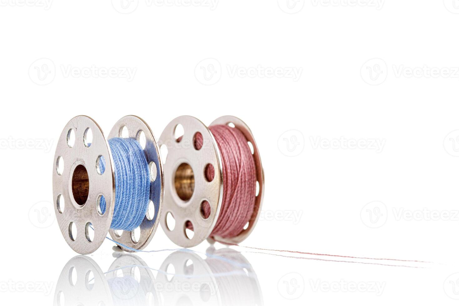 spools of blue and pink thread on a white background photo