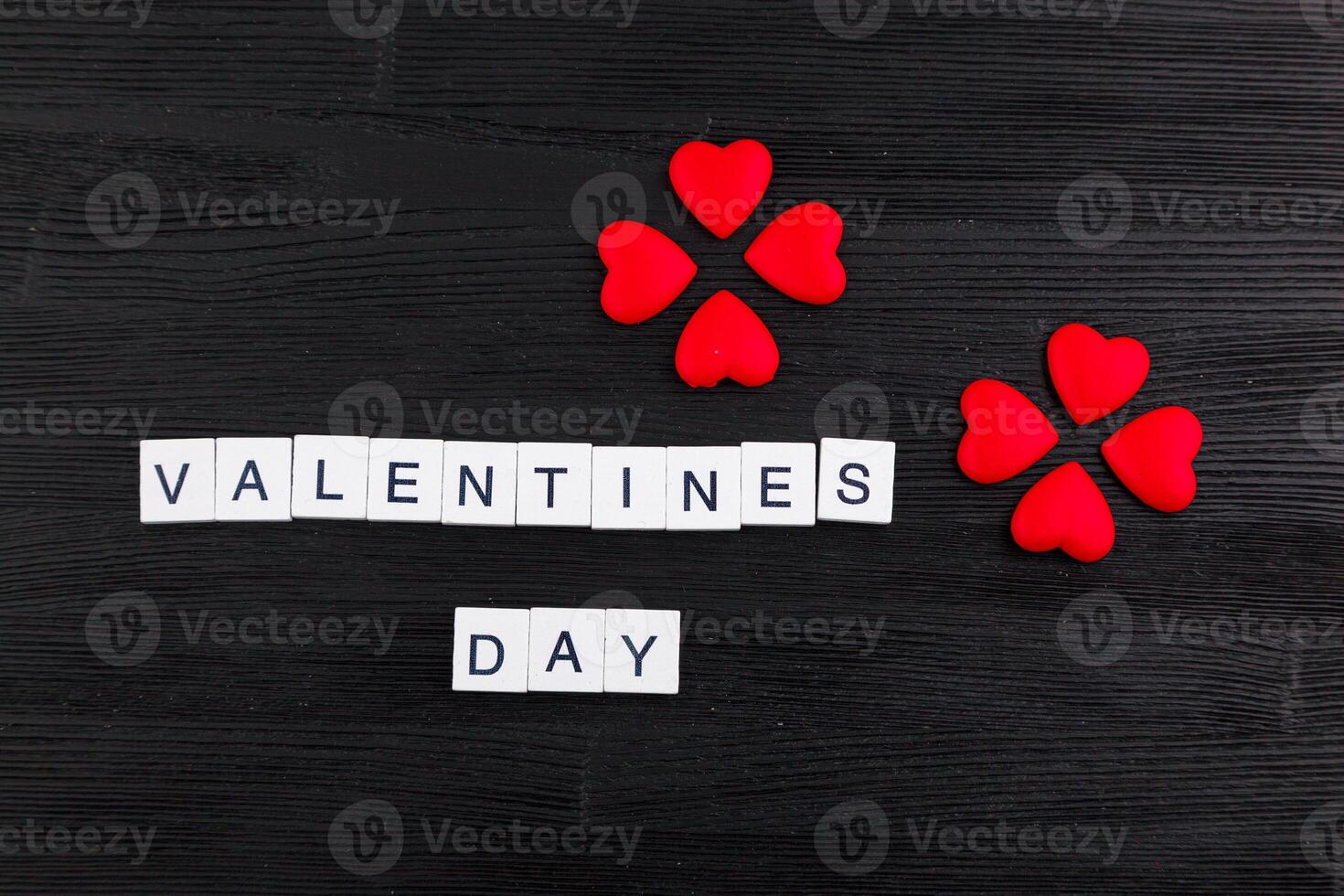 inscription Valentines day on a black wooden background photo