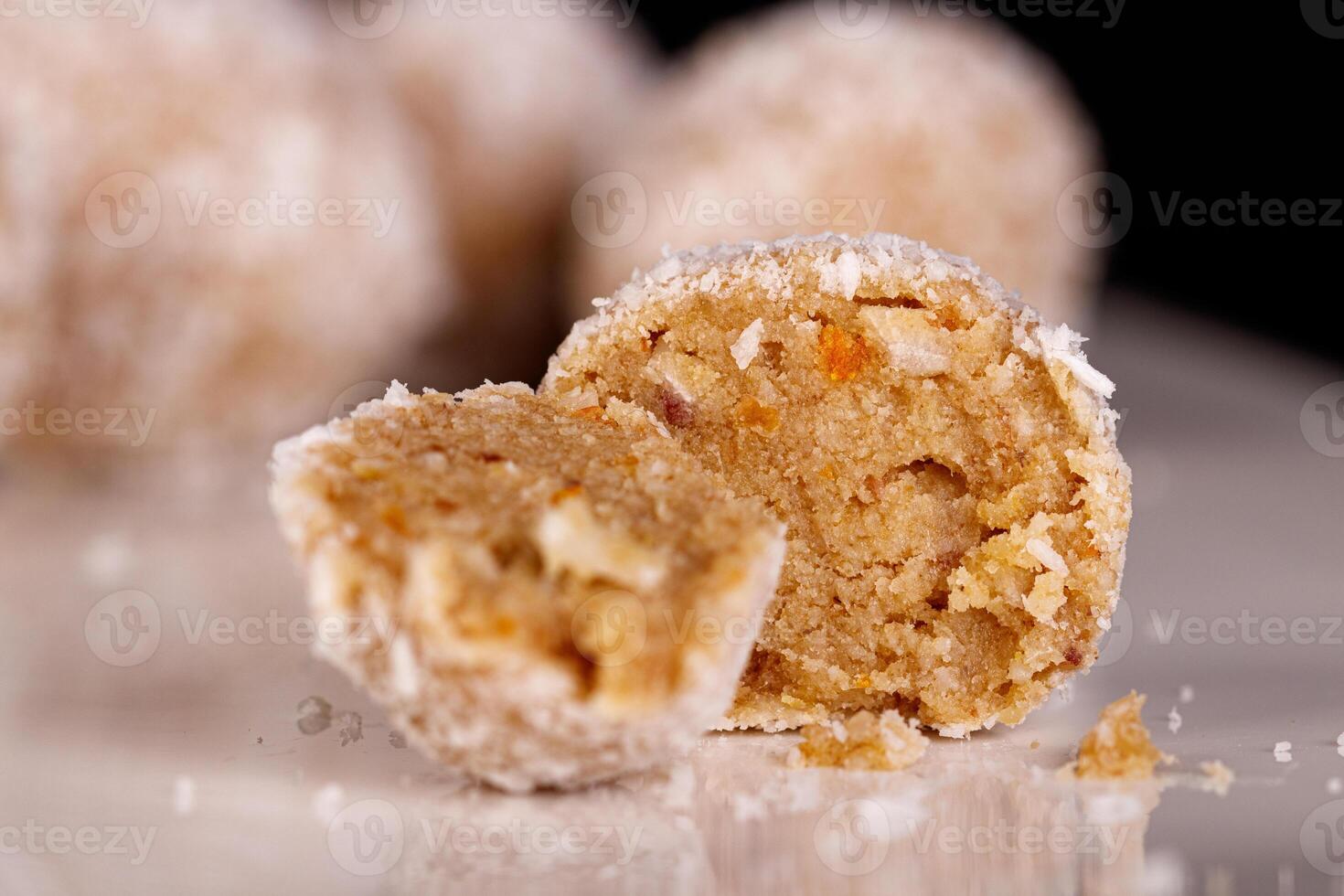 Beautiful sweets with coconut on a white plate on a black background photo