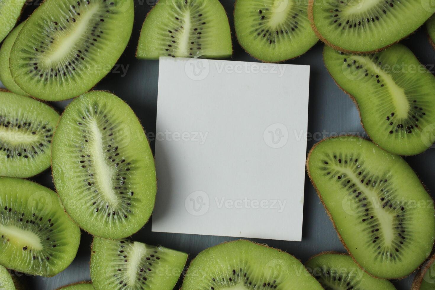 Kiwi mockup slices. A white sheet of paper to write down the mockup next to pieces of green kiwi. Kiwi Food Background photo