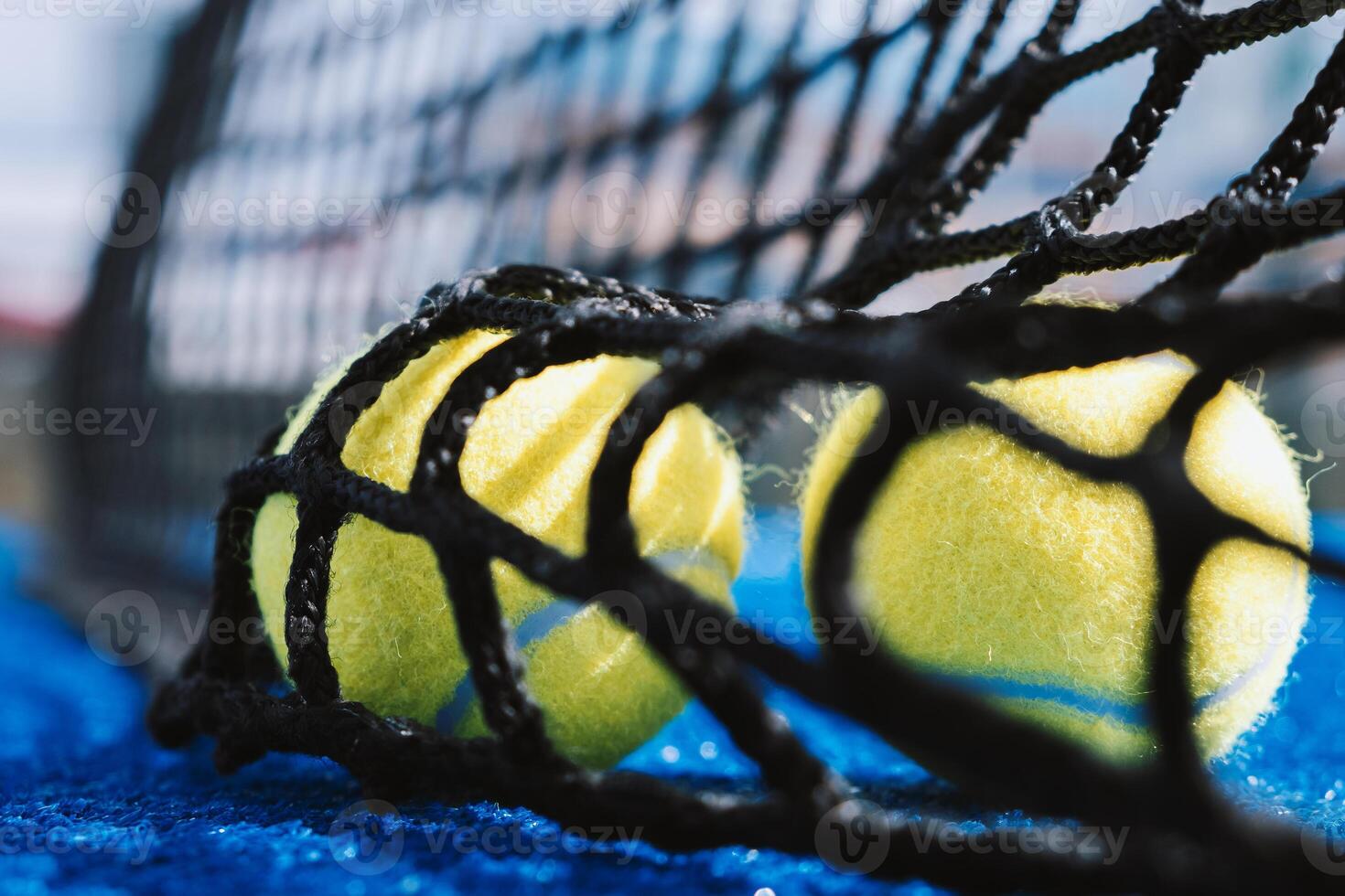two balls behind the net on a paddle tennis court, racket sport concept background photo