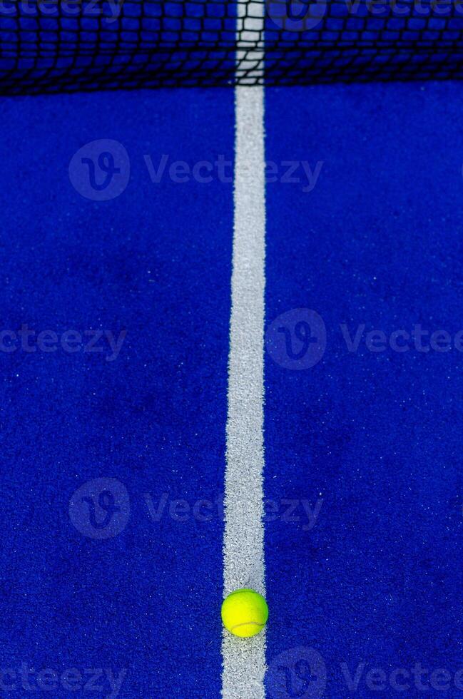 Overhead photo of the line of a blue synthetic paddle tennis court.