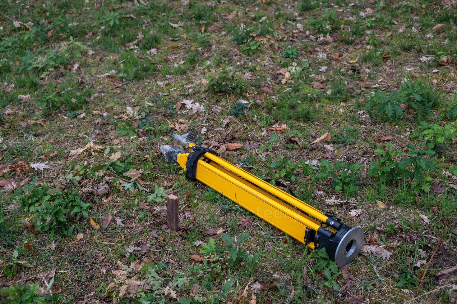 Stake driven into the ground as a topographic base and tripod for the total station. Survey work concept. photo