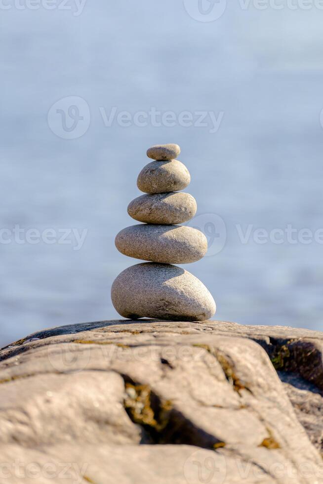 Pyramid of stones. Unstable balance of stone objects. Idyllic state of nature. photo