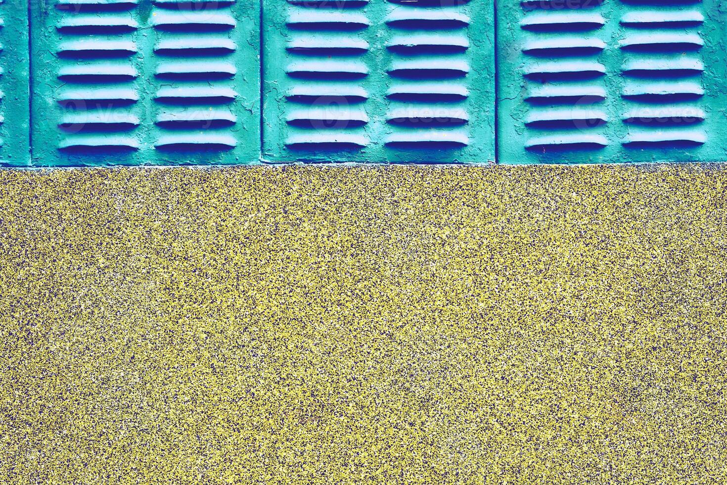 Old azure emerald grille ventilation holes lattice, wall with stone chips photo