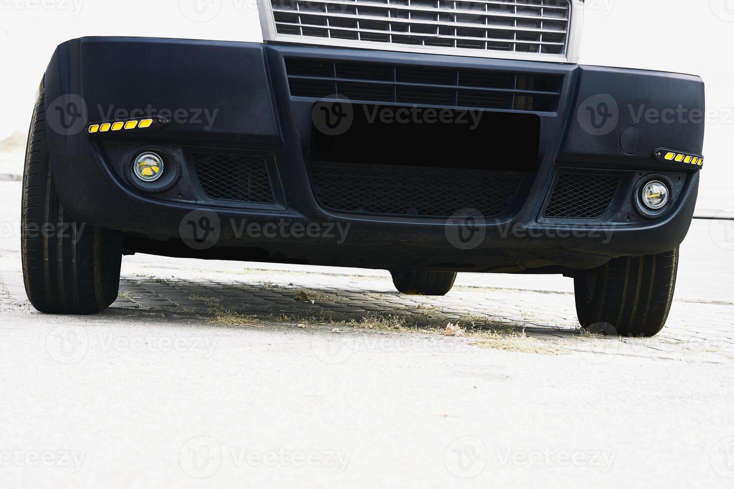 Fog light and LED side lights on black bumper in white photo