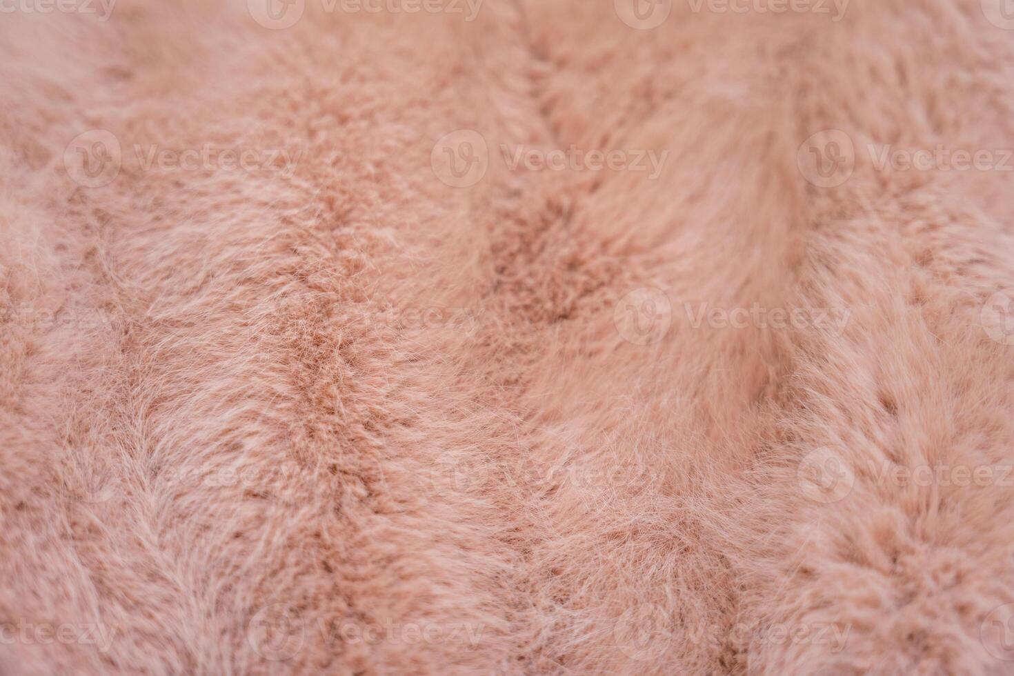 Soft texture of a faux fur coat in warm peach fuzz tones photo