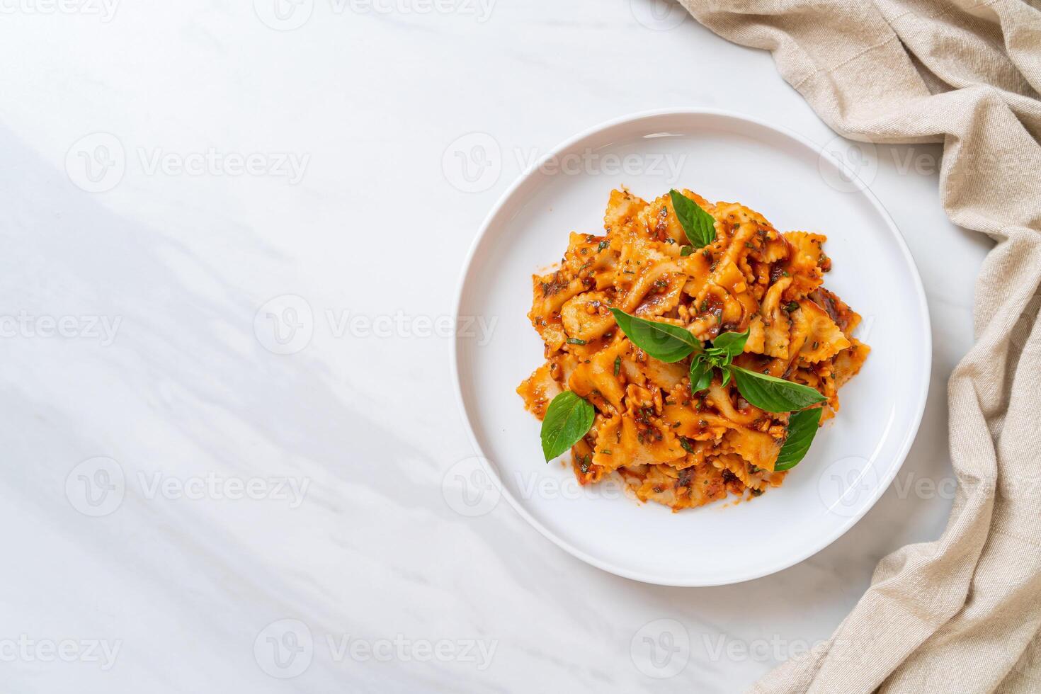 farfalle pasta with basil and garlic in tomato sauce photo