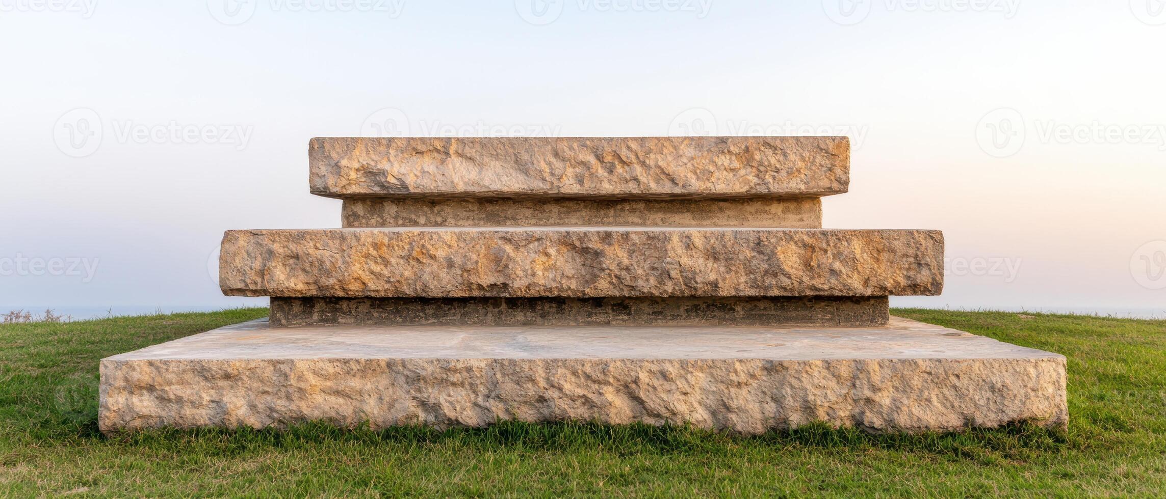 Stacked stone blocks on grassy field photo