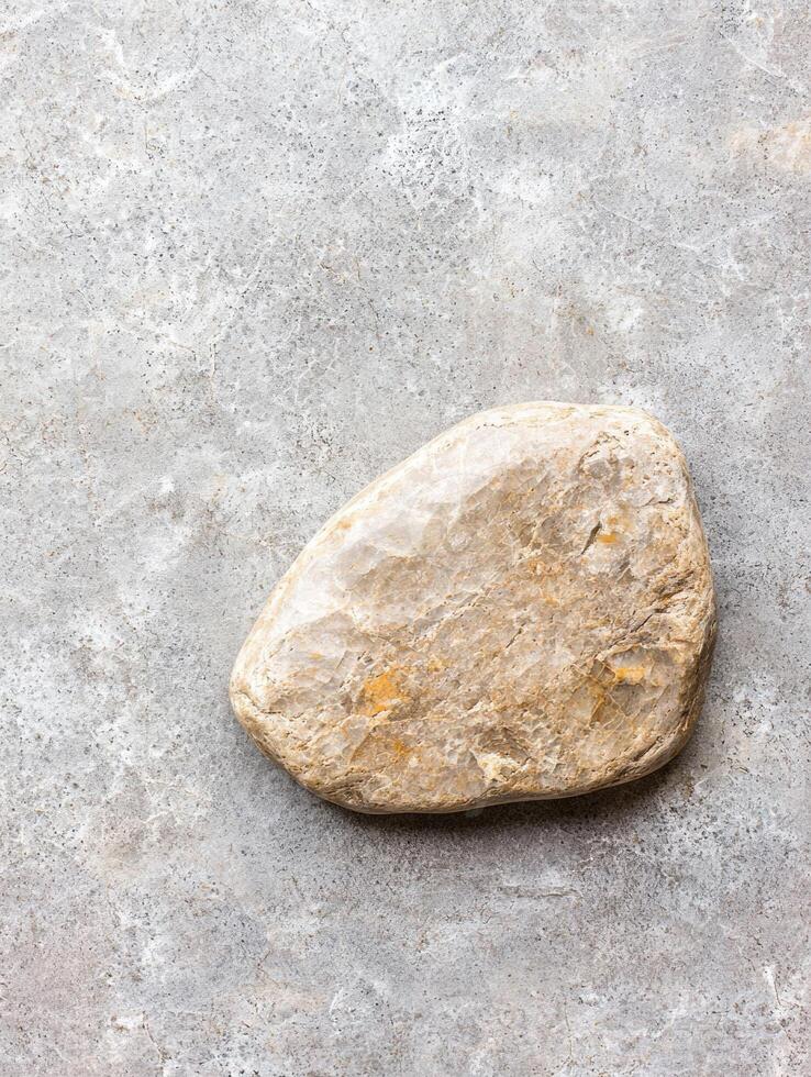 Smooth natural stone on concrete background photo