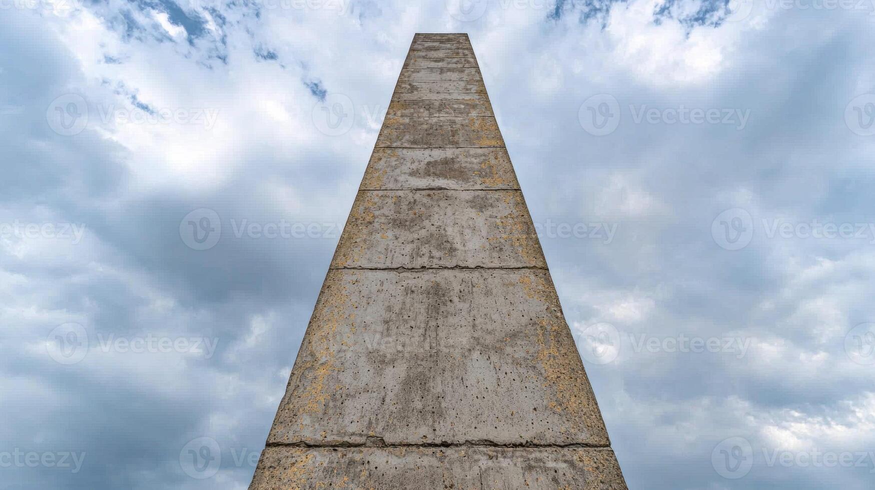 Tall concrete obelisk reaching into the cloudy sky photo