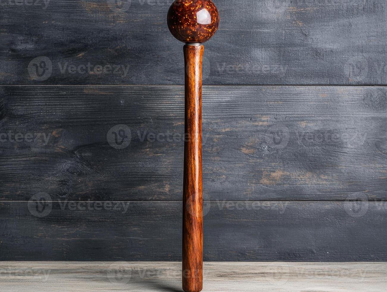 Wooden mallet with amber glass ball on dark wooden background photo