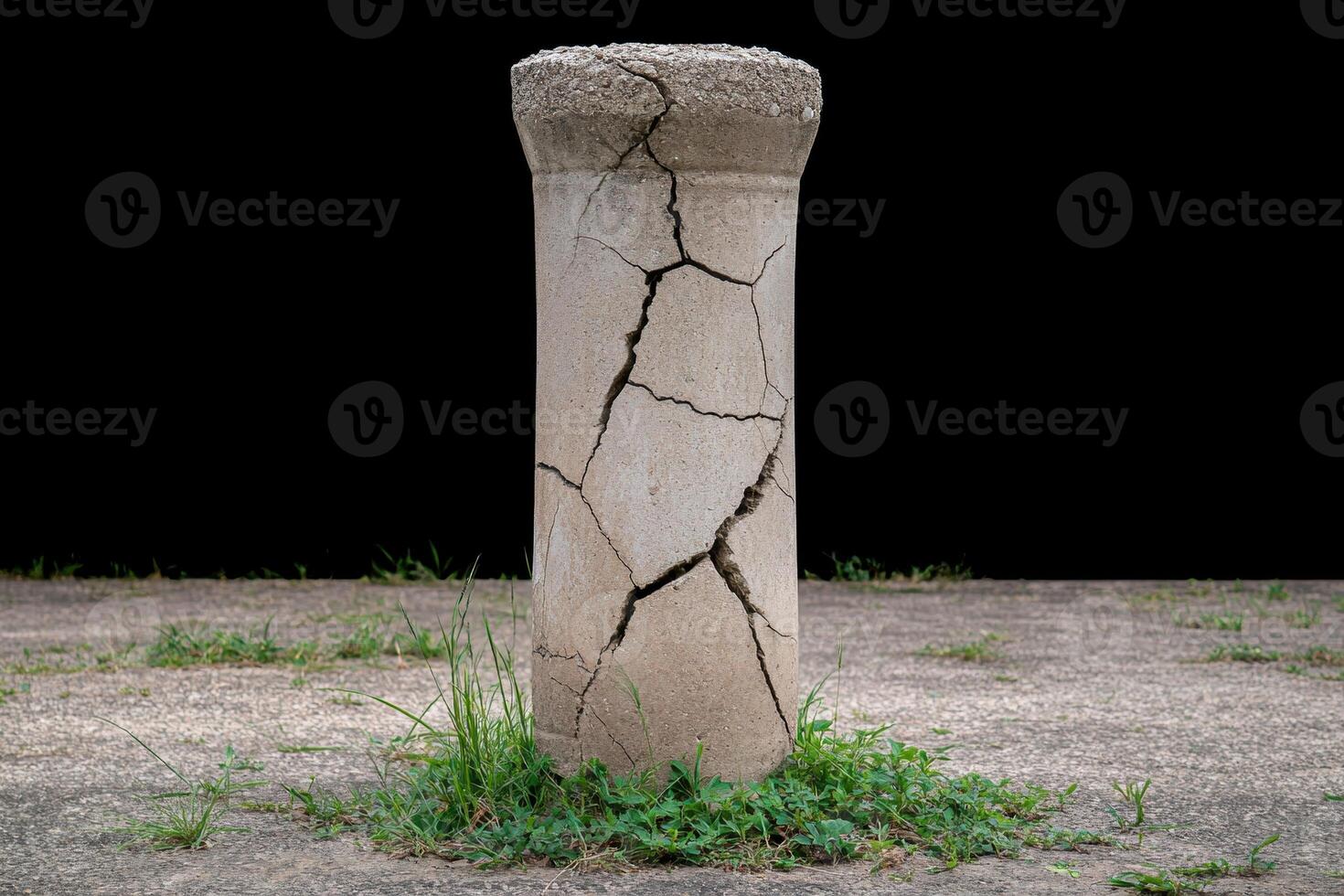 Cracked concrete pillar in grass photo