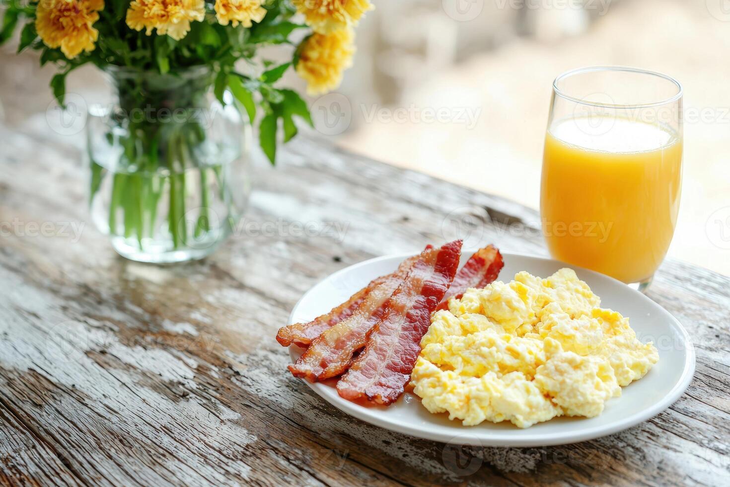 Delicious breakfast with scrambled eggs, bacon, and orange juice photo