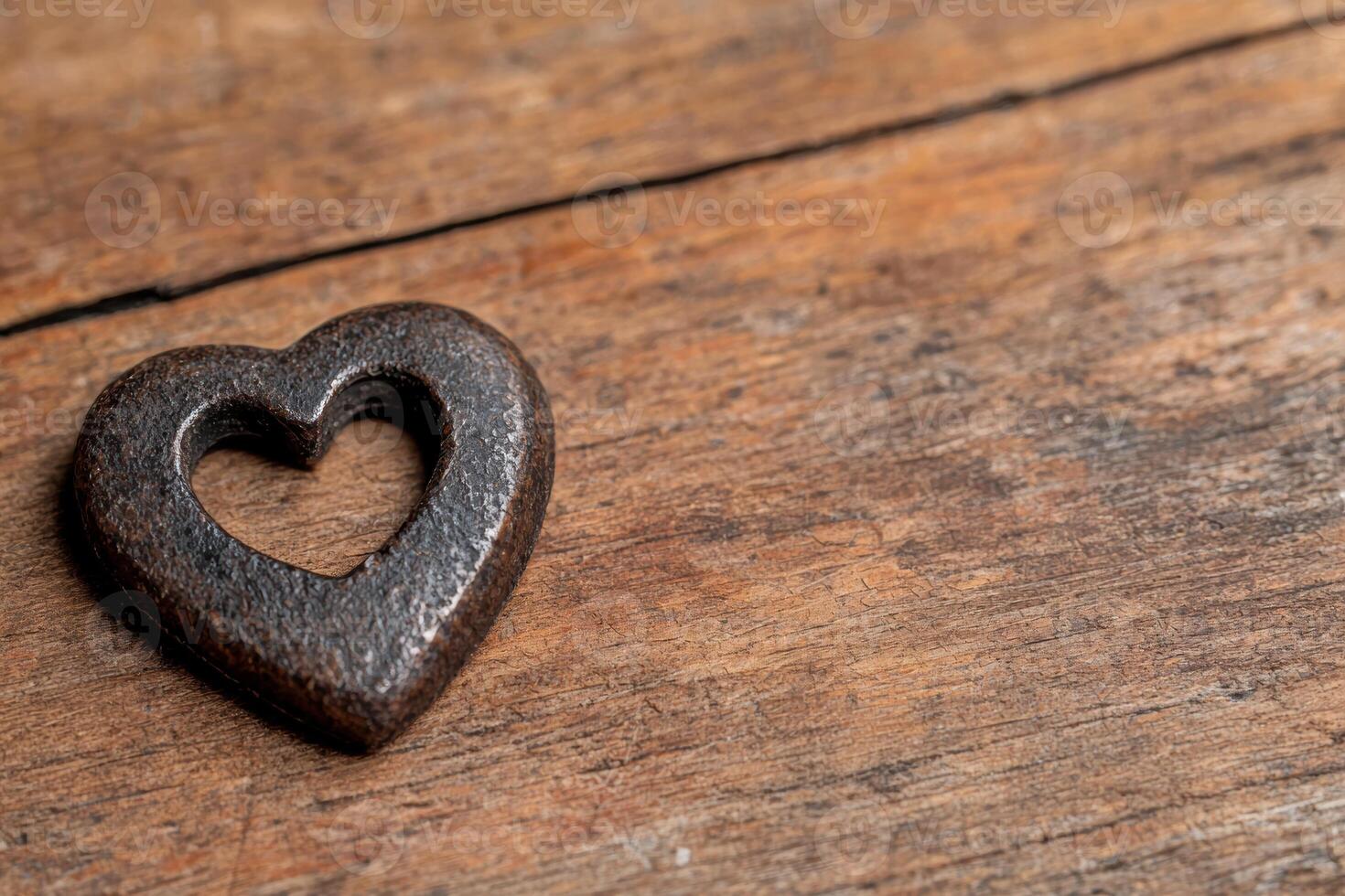 Rustic wooden background with heart shaped metal object photo