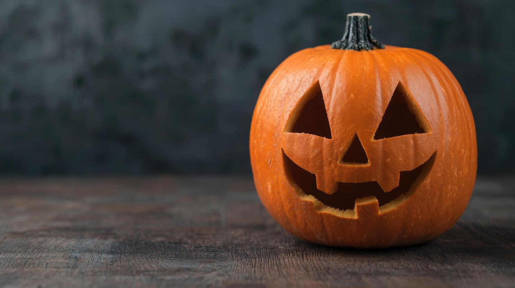 Carved Halloween pumpkin on wooden table photo