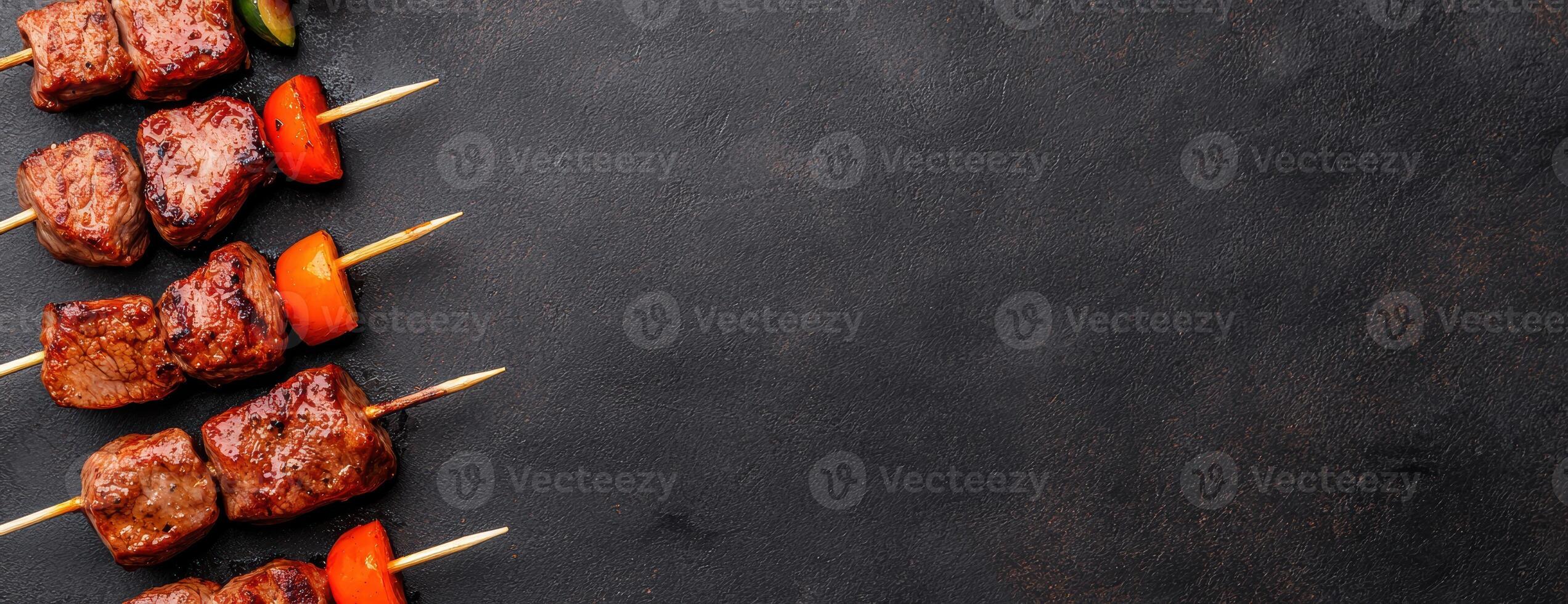 Grilled meat skewers with vegetables on dark background photo