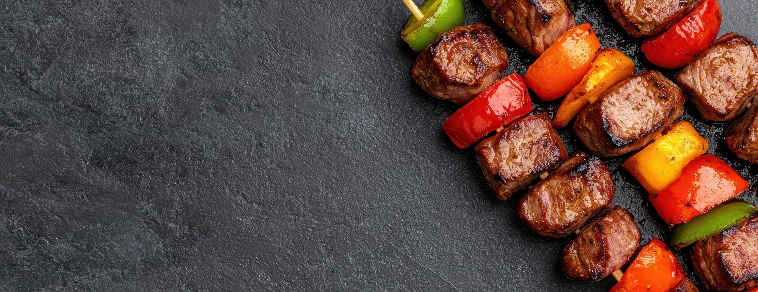 Grilled meat and vegetable skewers on dark background photo