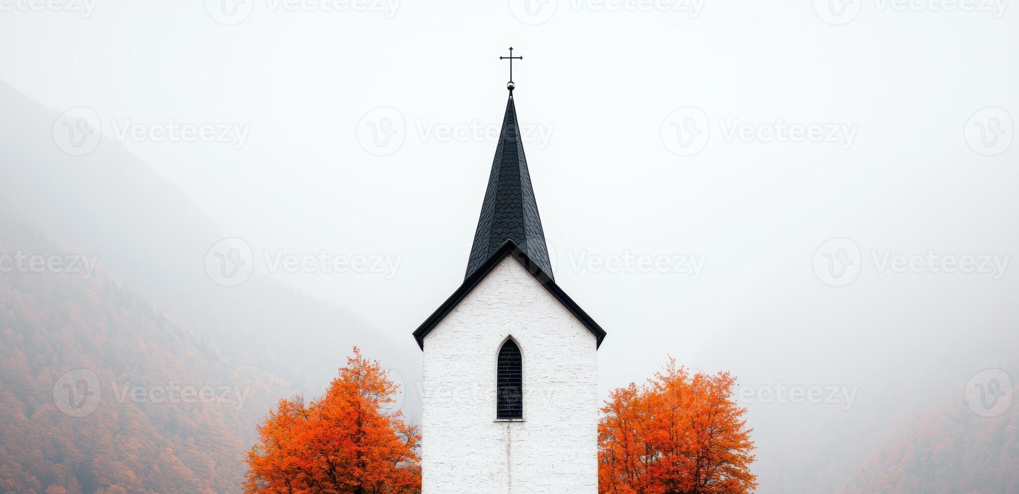 white church with black spire surrounded by autumn trees photo