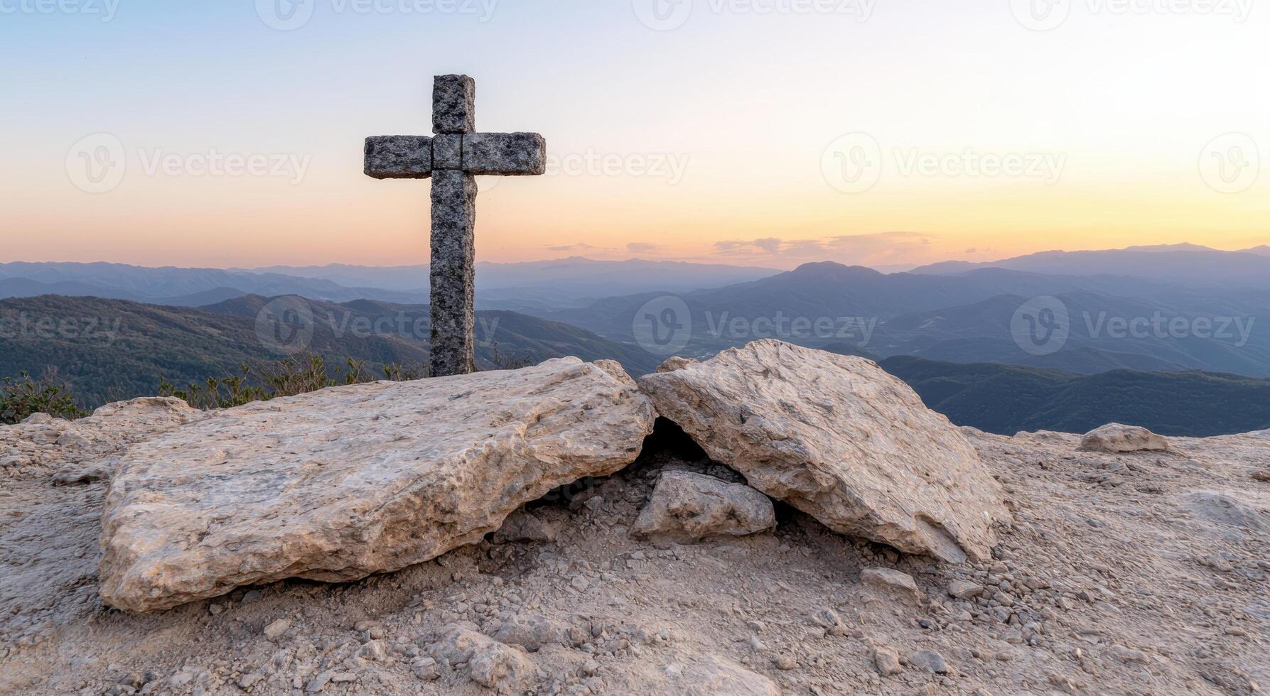 Cross on rocky mountain peak at sunset photo