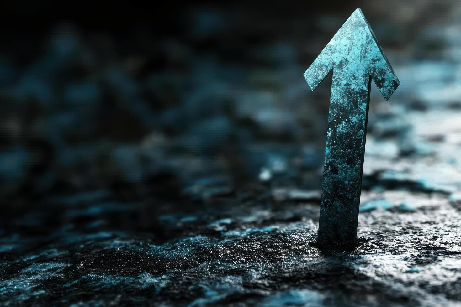 A blue arrow pointing up on a dark surface photo