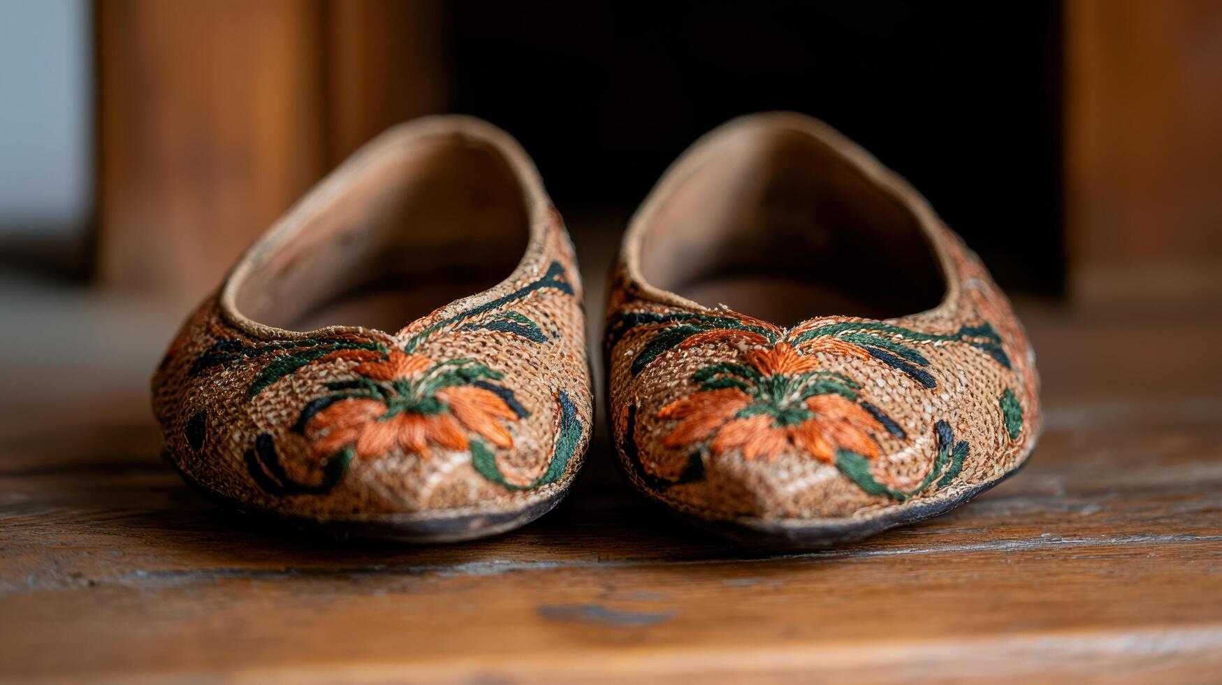 Ornate embroidered slippers on wooden floor photo
