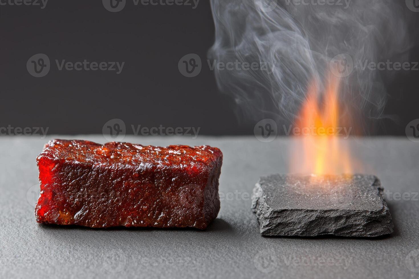 A piece of meat on a stone with a flame photo