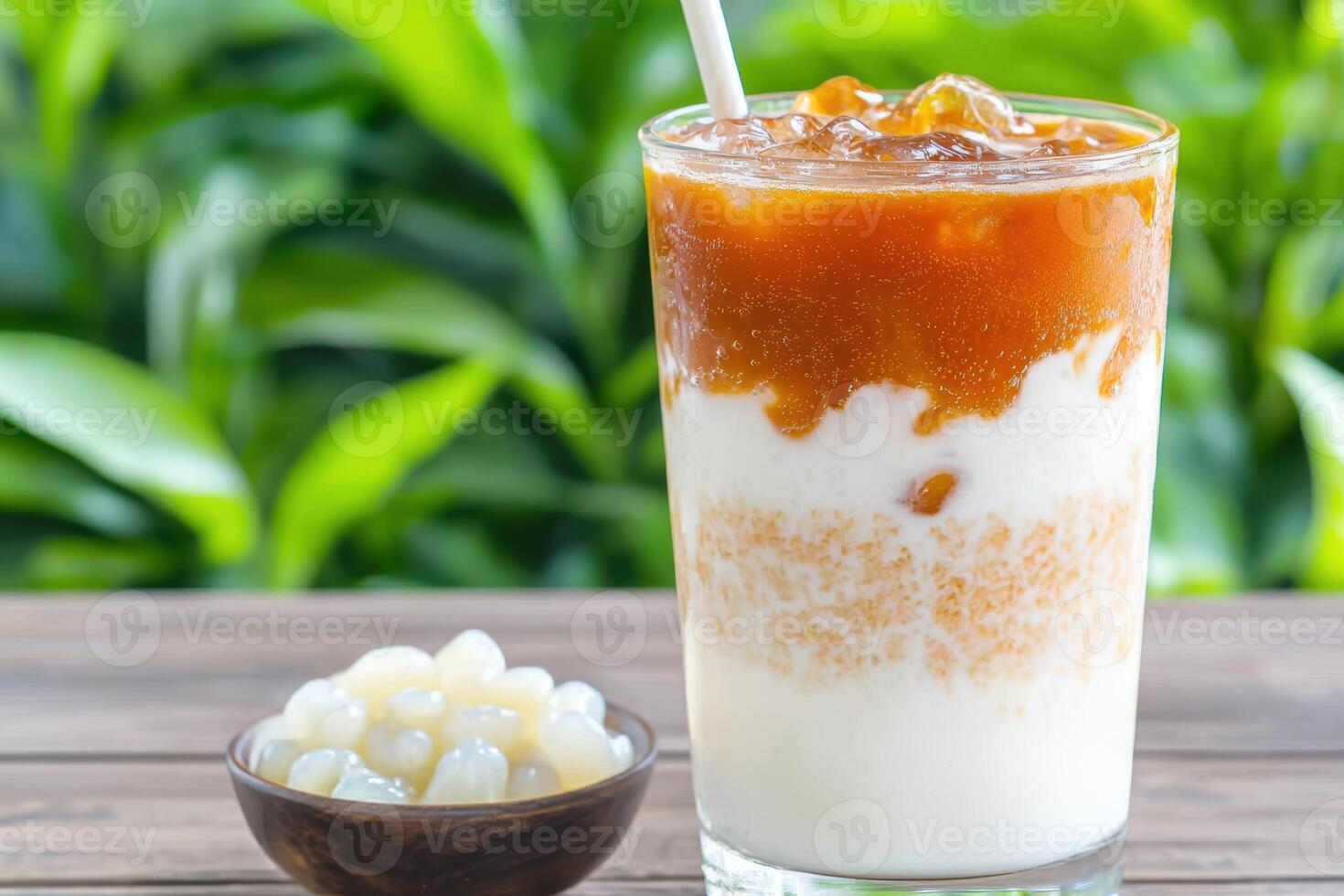 A glass of milk with a straw and a bowl of fruit photo