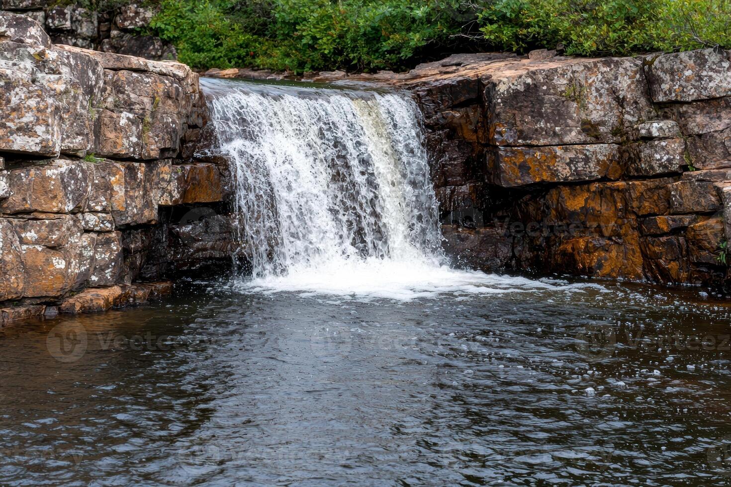 Serene waterfall cascading over rocky cliffside photo