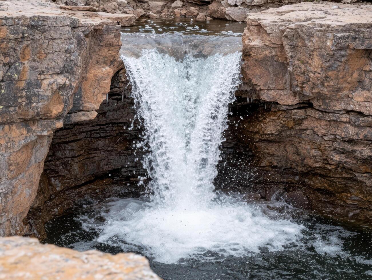 Cascading waterfall flowing through rocky cliffside photo