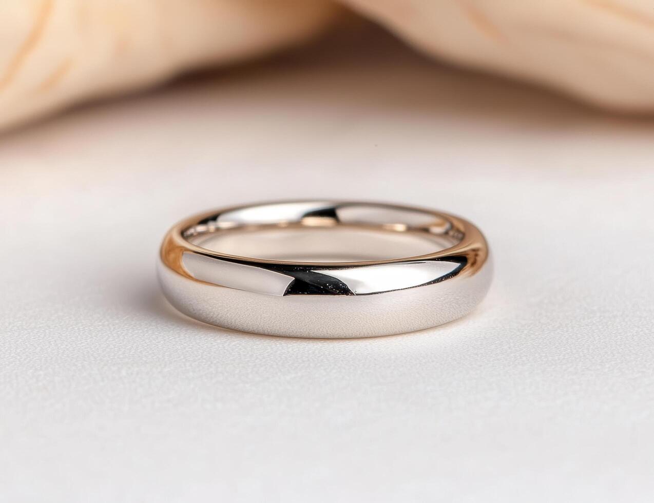 Shiny metal wedding ring on a light background photo