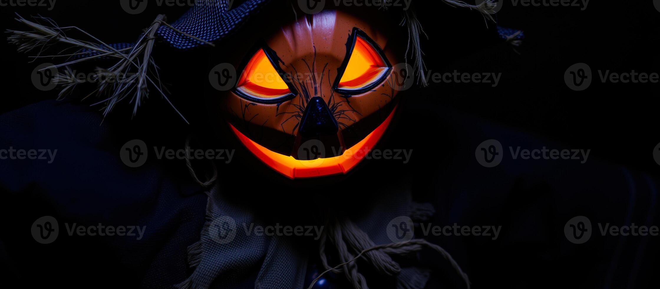 luminous carved pumpkin face with a straw hat photo