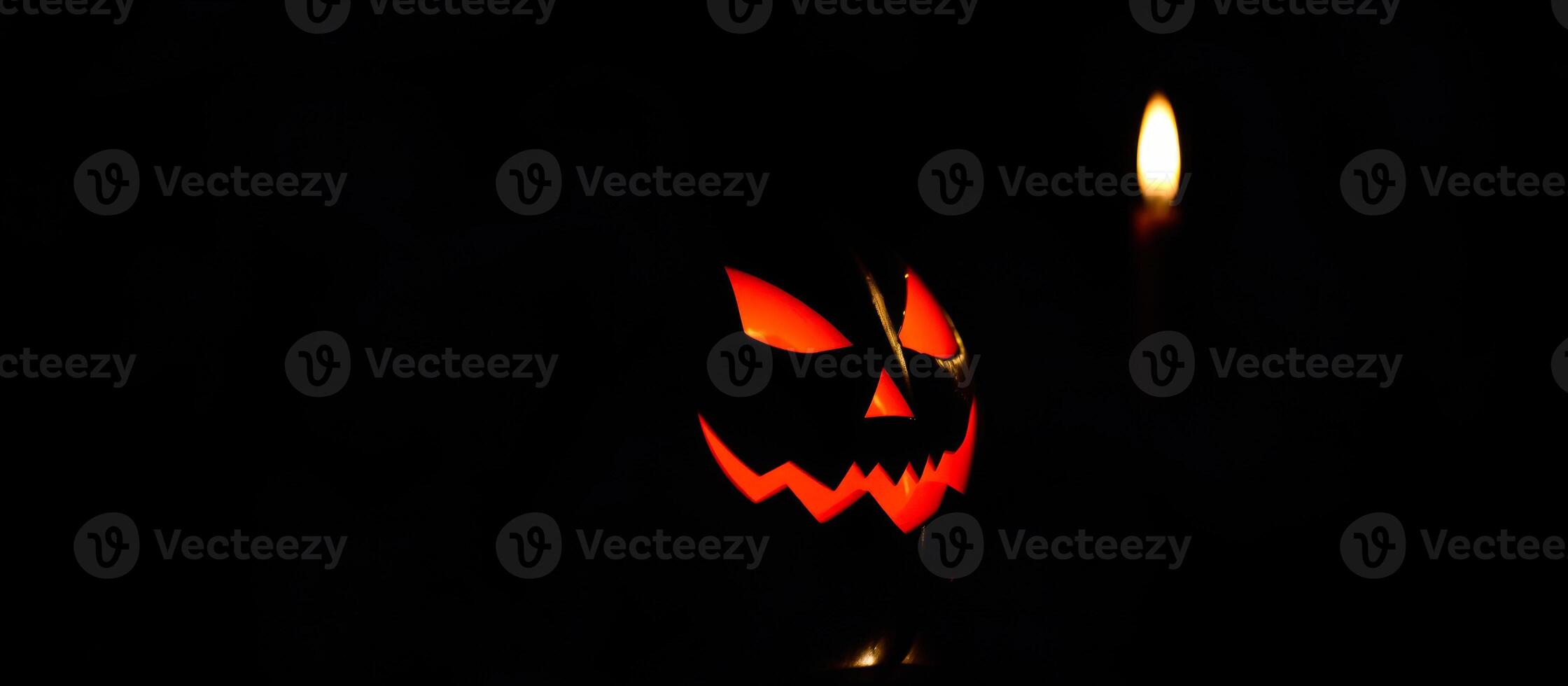 carved pumpkin with a lit candle creates a spooky atmosphere photo