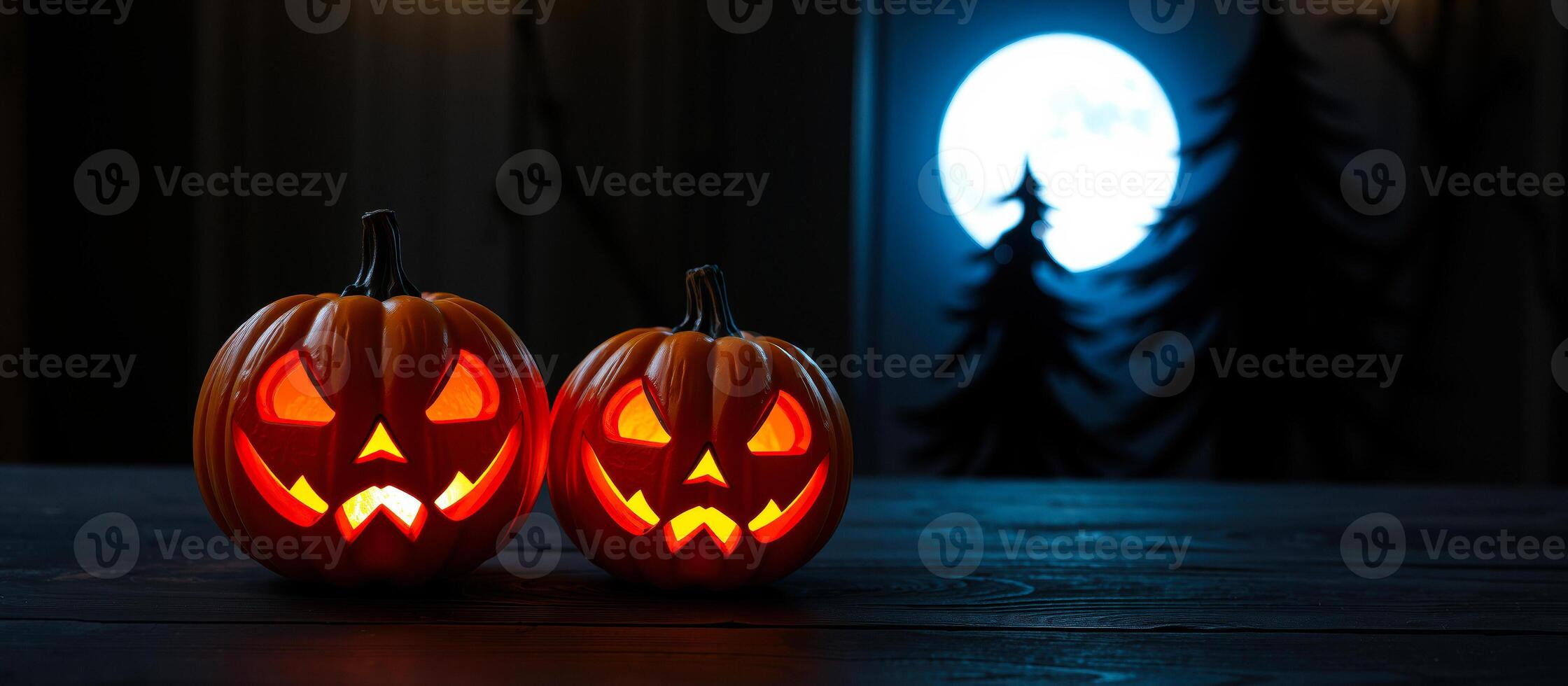two luminous jack-o'-lanterns on a dark tabletop photo