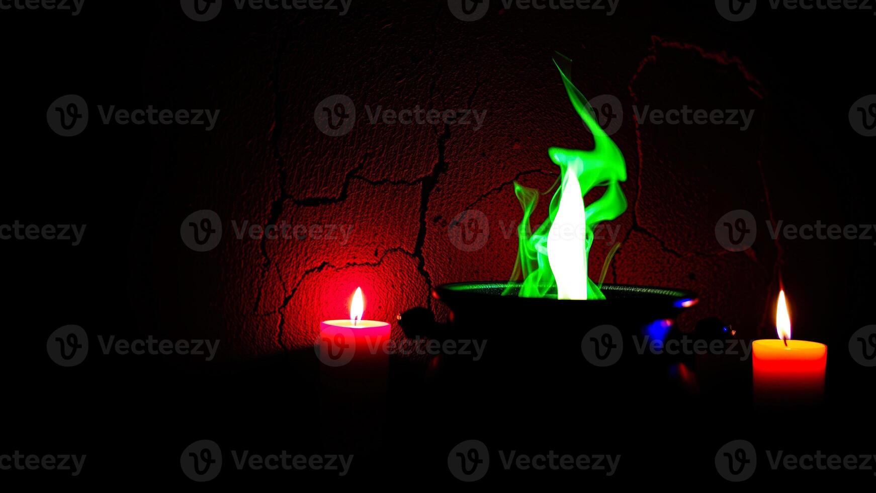 cauldron with a green flame red candles photo