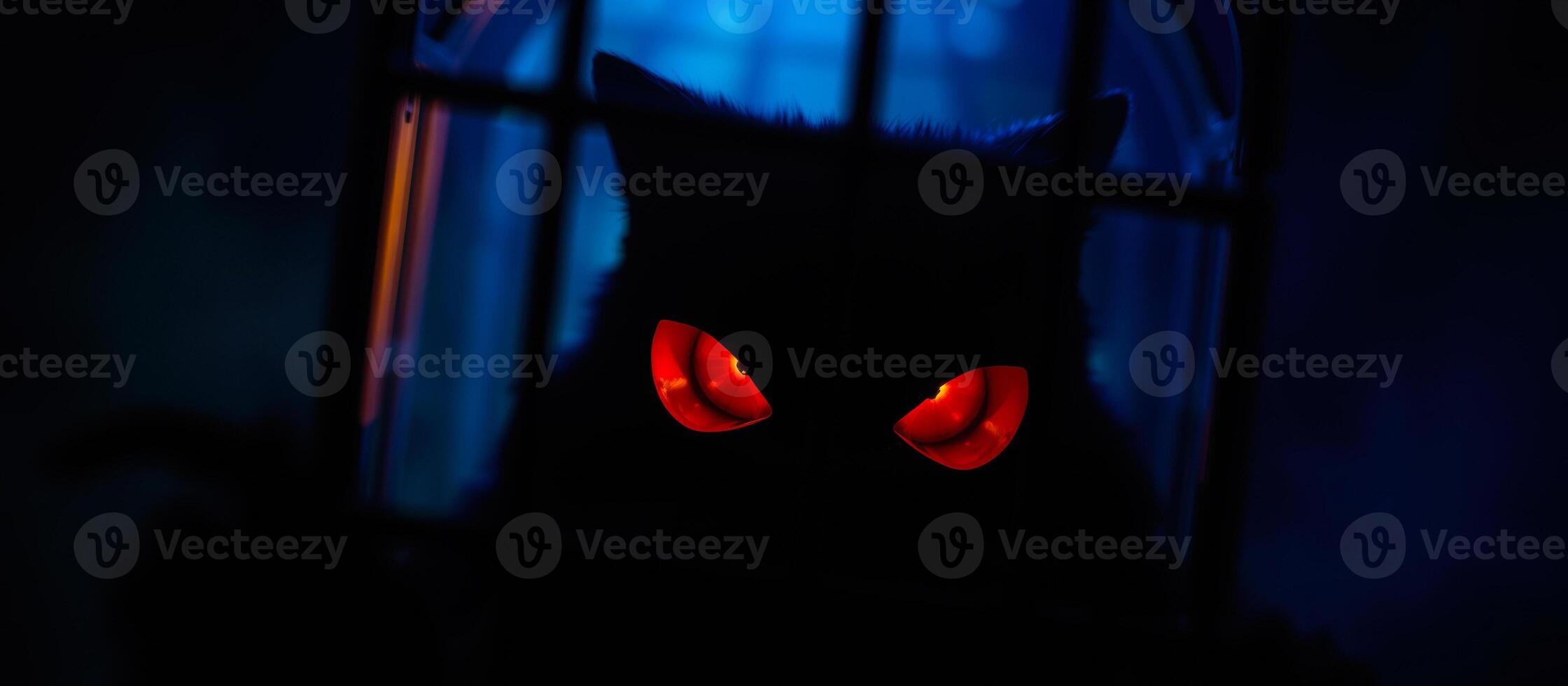 glowing red eyes peer from a dark cage photo