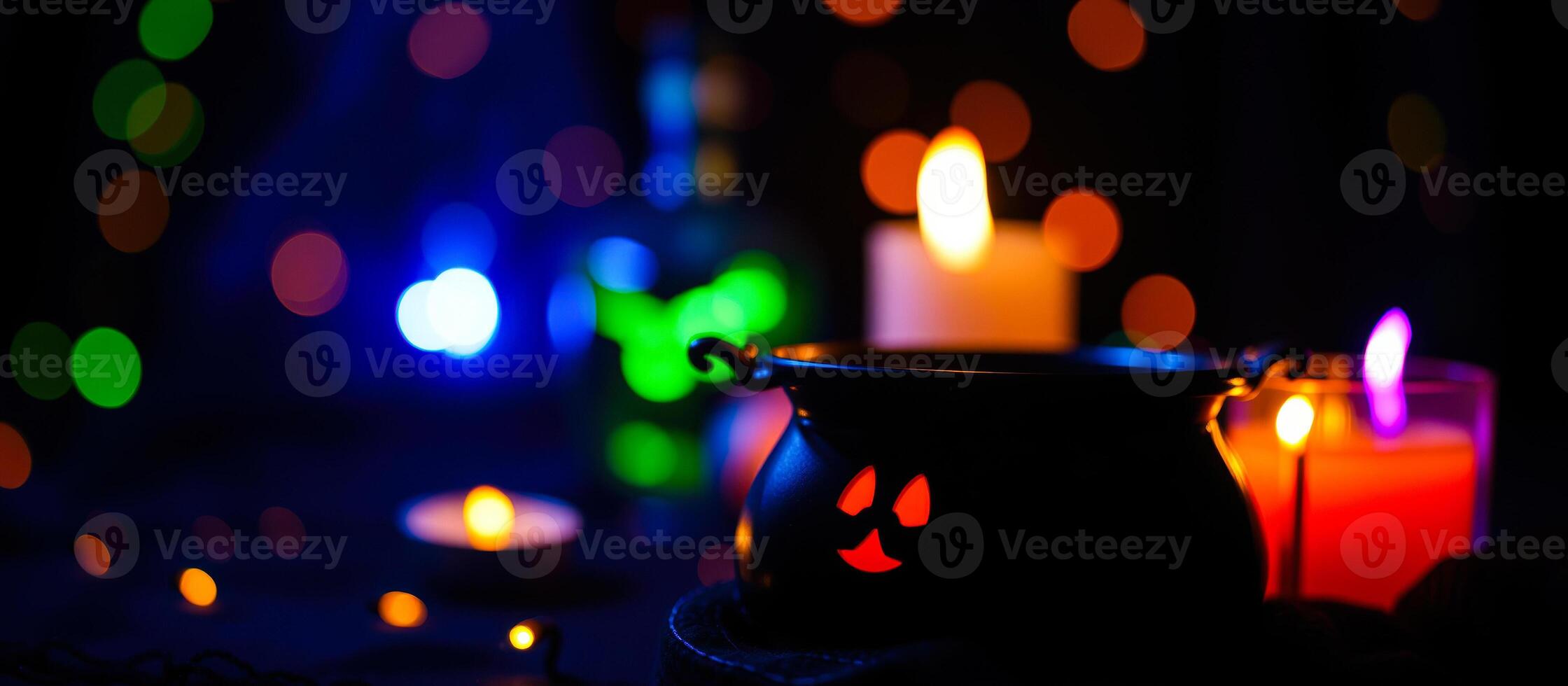 black cauldron with glowing red face surrounded by lights photo