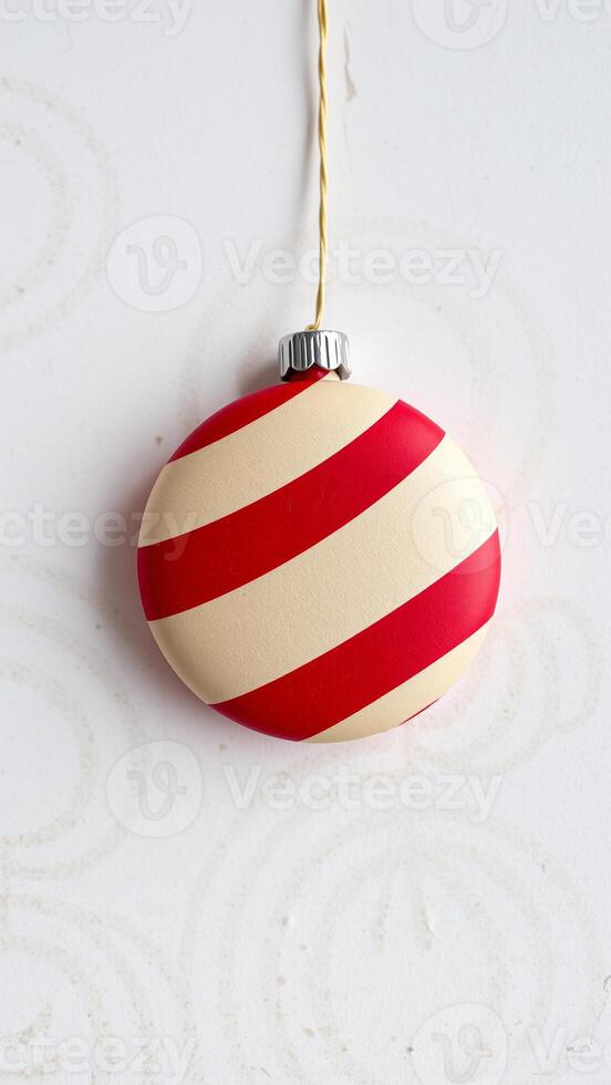 single cream red striped ornament hanging from a golden string photo