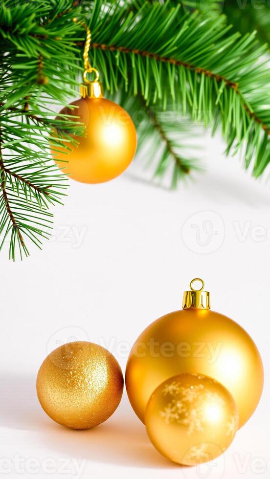 three gold ornaments resting on a white surface with a pine branch photo