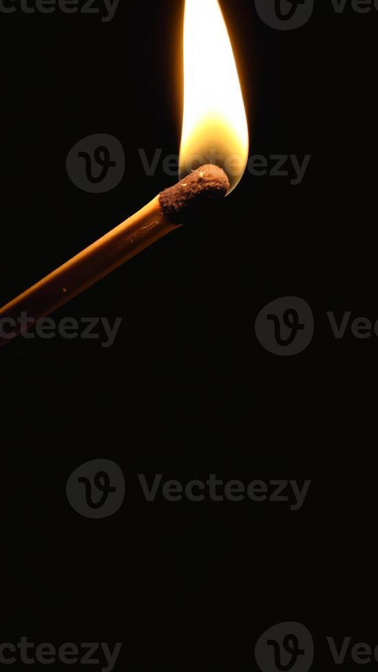 single matchstick blazing with a yellow flame photo