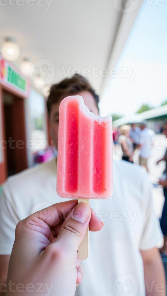 person holding a pink popsicle photo