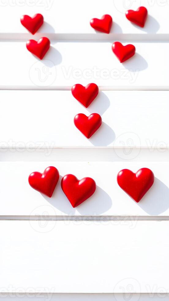 red heart decorations on a white wooden surface photo