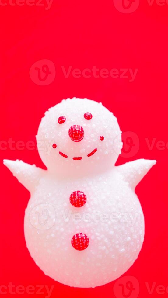white snowman figurine with red buttons on a red background photo