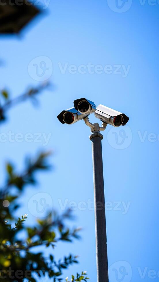 triple-lens security camera mounted on a pole against a blue sky photo